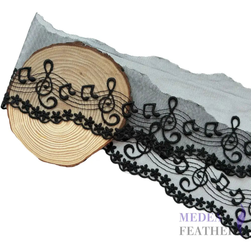 Black and off-white tulle lace trim with embroidered music note patterns. - Black