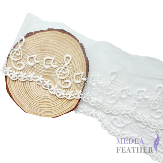 Black and off-white tulle lace trim with embroidered music note patterns. - White